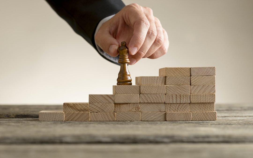 Businessman moving the queen piece up a series of steps